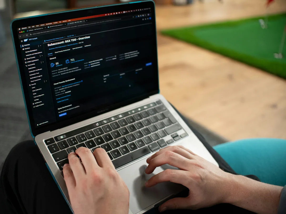Hands typing on a laptop keyboard with a settings-style screen open