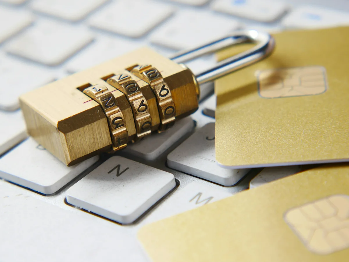 A gold combination padlock resting on a computer keyboard